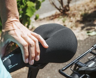 A man's hand holds the wheel on the Terry saddle 