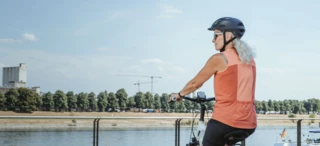 A woman rides her bicycle along the shore