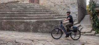 A man rides an e-bike through a city