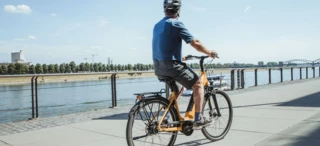 Cyclist riding along a river bank